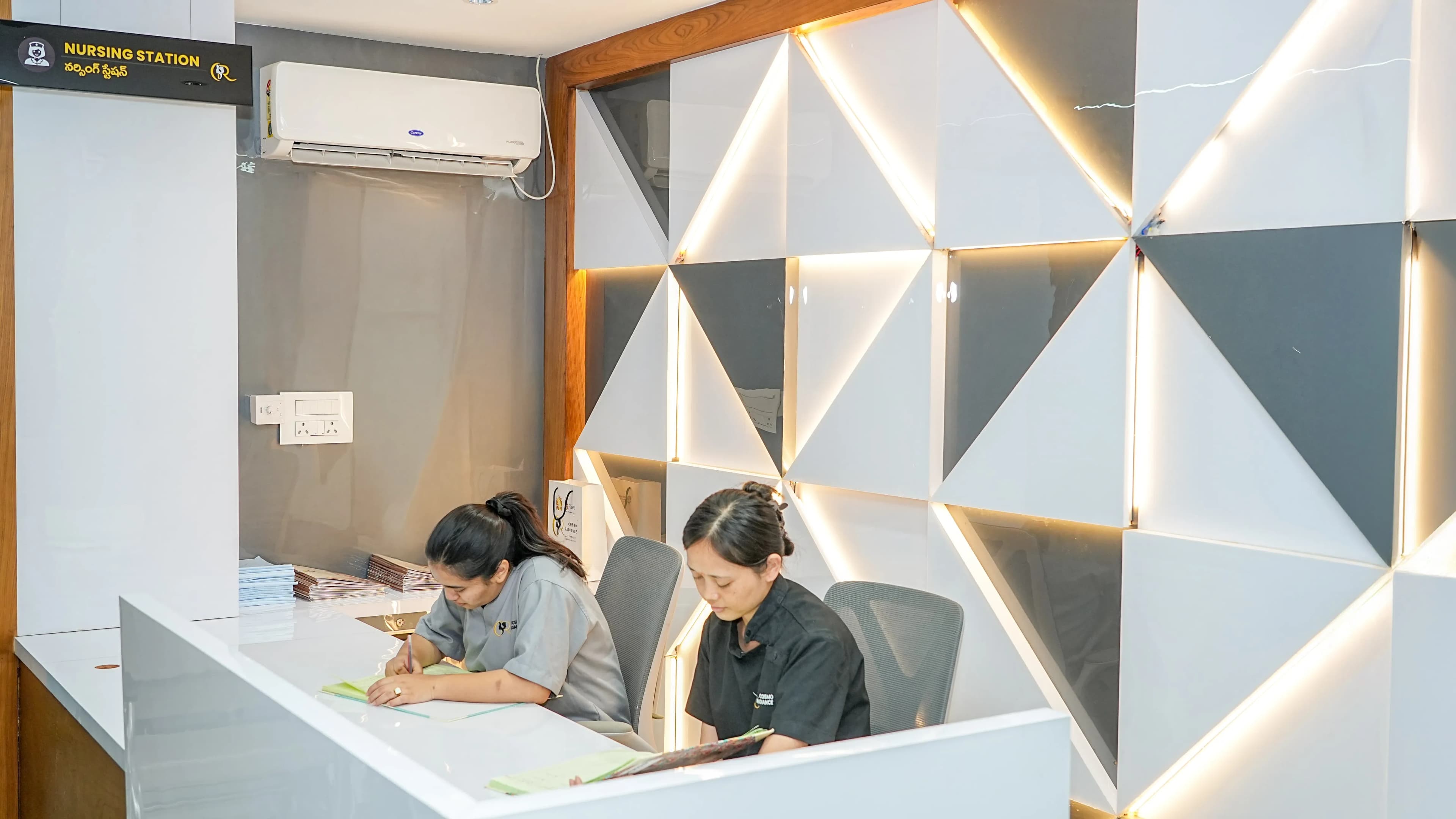 Central nursing station staffed by professionals, equipped with Etticos nurse calling LCD screen, crash carts, and medication trolleys