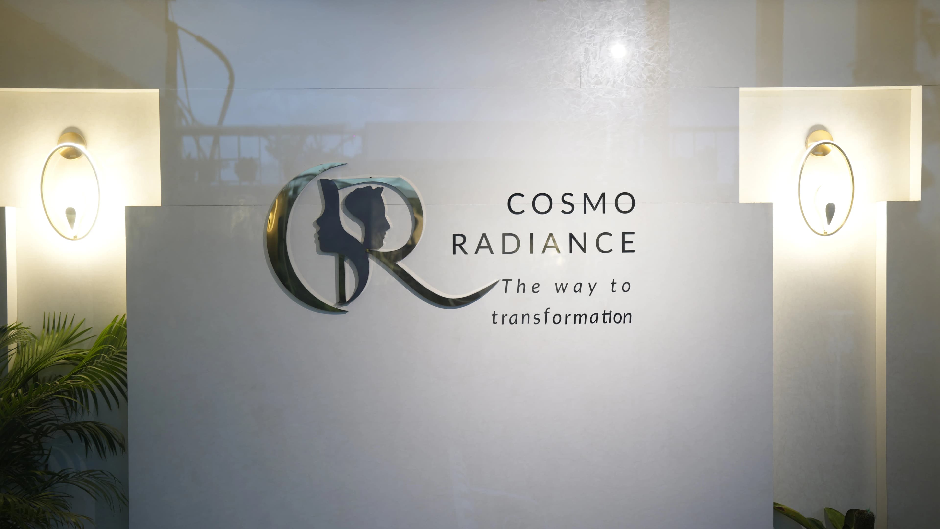 Illuminated Cosmo Radiance logo mounted on a pristine white wall