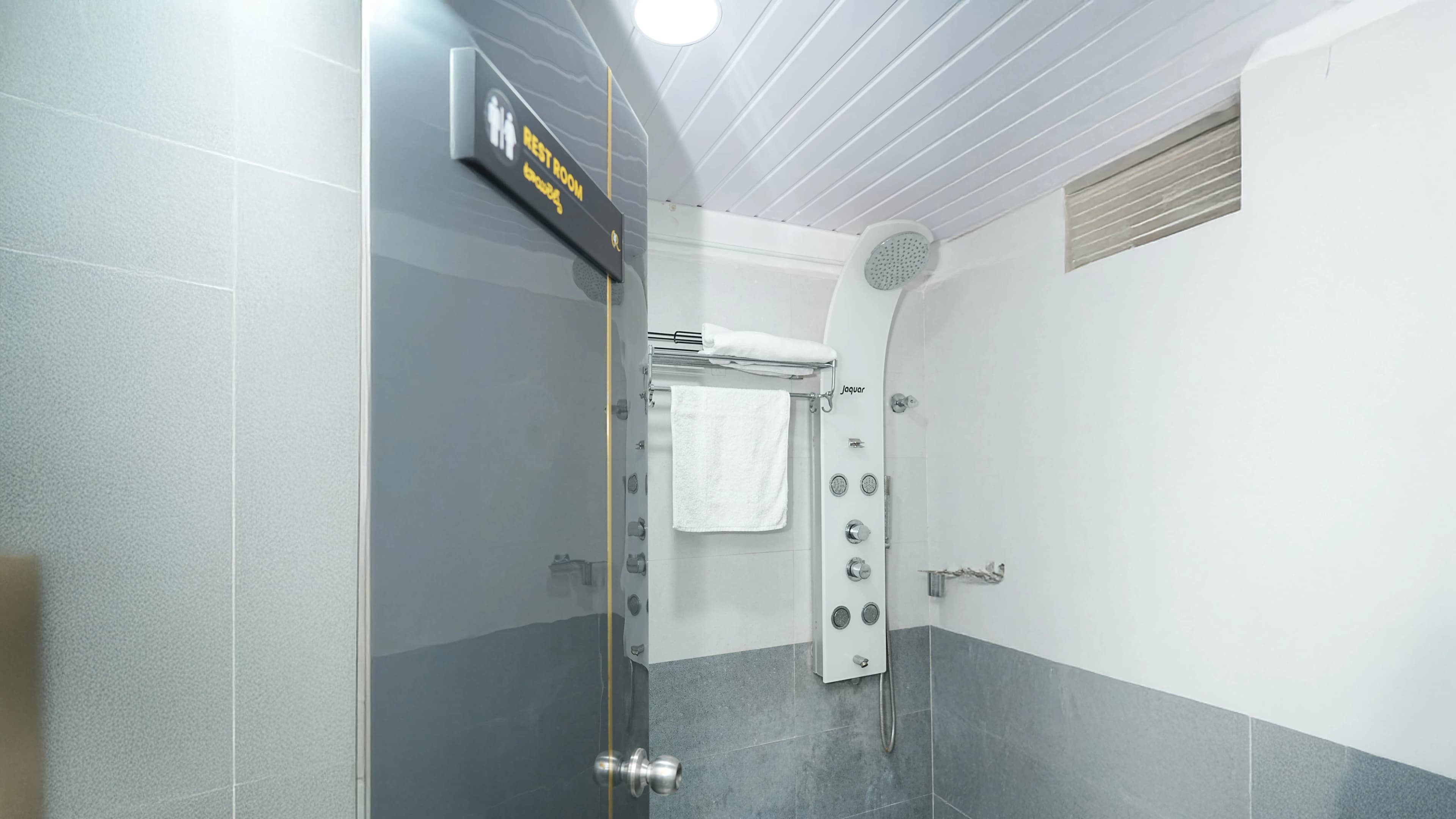 Private changing room with a dedicated Jaquar shower panel with fresh towels for laser hair removal patients at Cosmo Radiance, ensuring maximum hygiene and comfort.