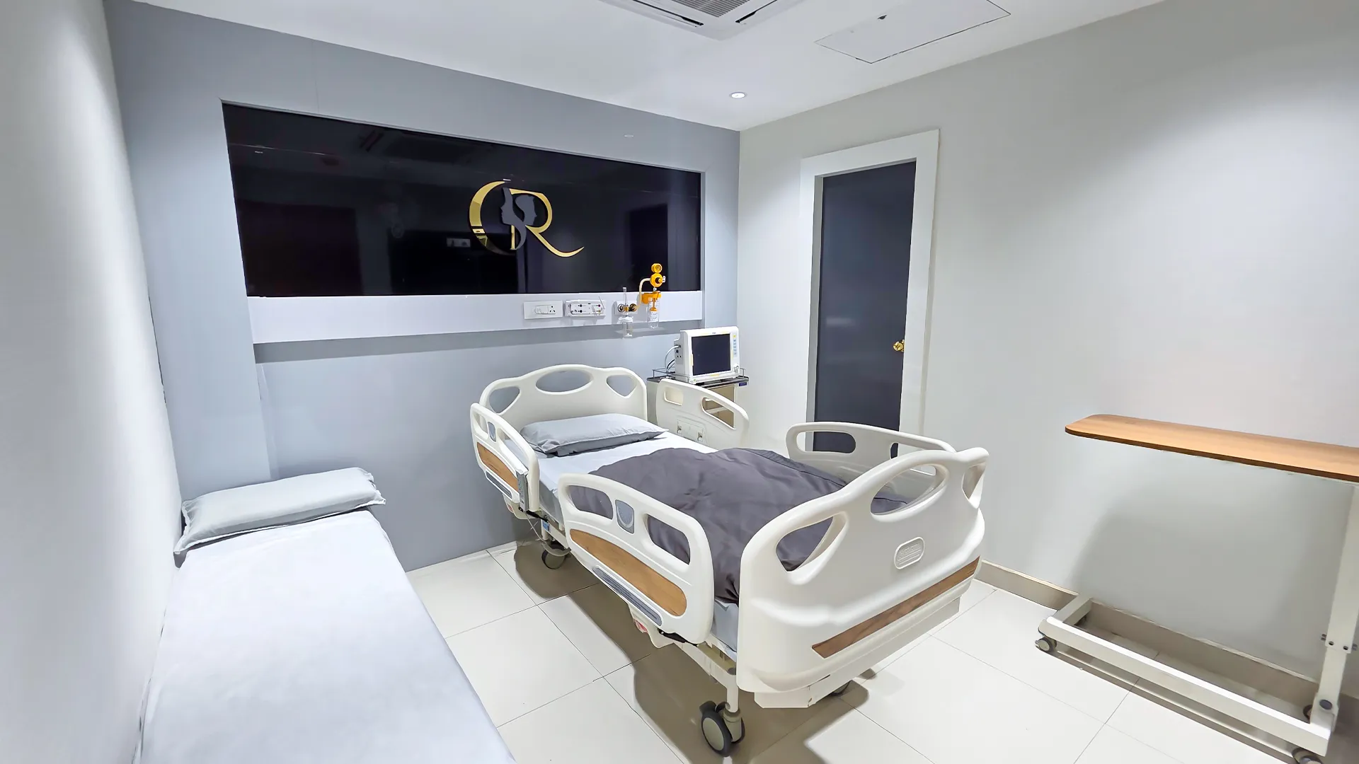 Spacious patient suite interior with marble wall finishes, attendant bedding, and large natural light windows